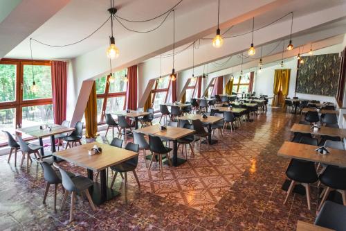 a dining room with tables and chairs and windows at Perła Świeradowa in Świeradów-Zdrój