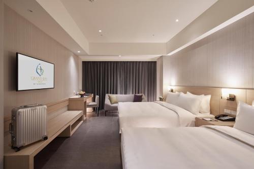 a hotel room with two beds and a television at Grand Bay Resort Hotel in Hengchun