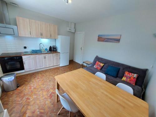 un salon avec un canapé et une table en bois dans l'établissement VILLA REVE D'OCEAN climatisée, à Gujan-Mestras