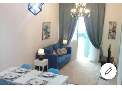a living room with a blue couch and a table at Muslim Boutique Apartment with Balcony in Tanah Rata