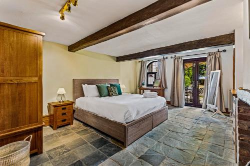 ein Schlafzimmer mit einem großen Bett und einem Fenster in der Unterkunft Rustic 5 Bed Farm House in Derbyshire, sleeps 9 