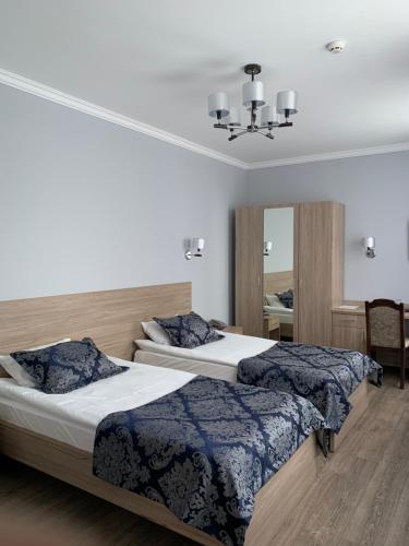a bedroom with two beds and a mirror at Nurtau in Pavlodar