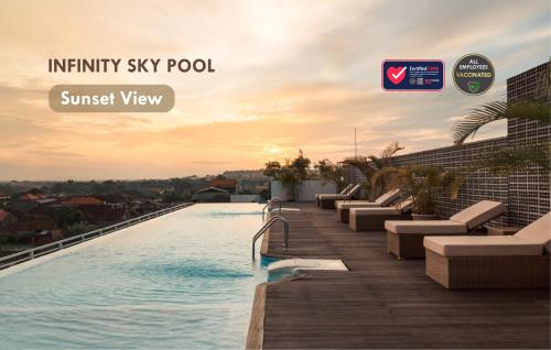 a swimming pool on top of a building with a sunset at Infinity8 Bali in Jimbaran