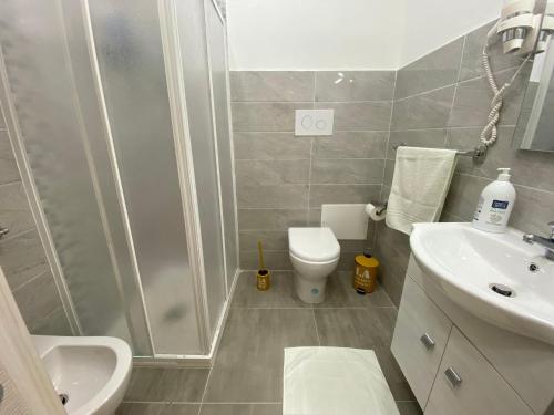 a bathroom with a shower and a toilet and a sink at Si Viaggiare Apartments in Partinico