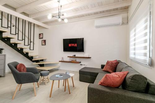 a living room with a couch and a tv at S&K Luxury Μaisonette in Potamós