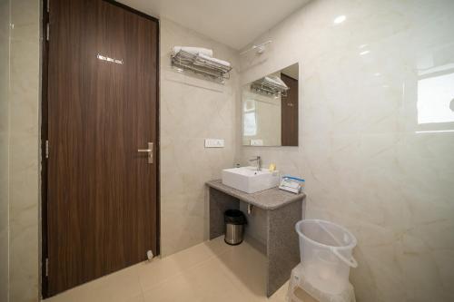 W łazience znajduje się umywalka i lustro. w obiekcie Sheerha Royal Residency w mieście Dżajpur