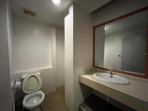 ein Badezimmer mit einem WC, einem Waschbecken und einem Spiegel in der Unterkunft Naraigrand Hotel (โรงแรมนารายณ์แกรนด์) in Chai Badan