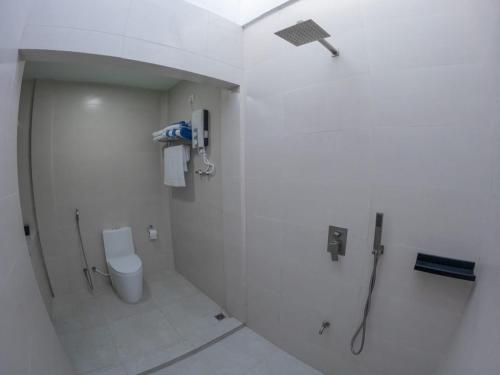 a white bathroom with a shower and a toilet at Clouds Beach Retreat Laamu Gan in Gan