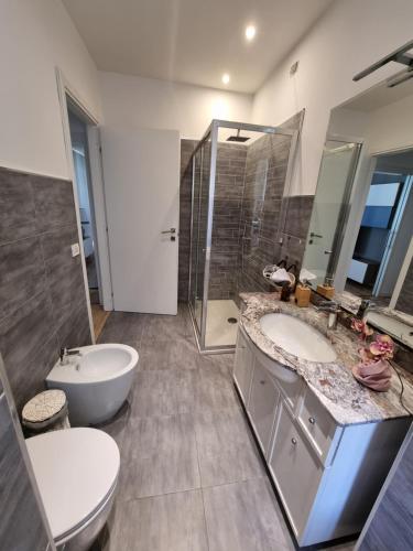 uma casa de banho com 2 lavatórios, um chuveiro e um WC. em Bartolo43 em Perugia