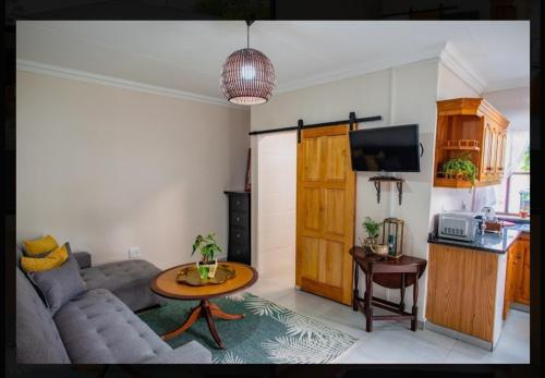 a living room with a couch and a table at Die Hof Gastehuis in Kroonstad