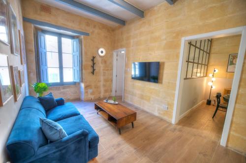 un soggiorno con un divano blu e un tavolo di Beautifully furnished flat in the city center JBAL1-1 a La Valletta