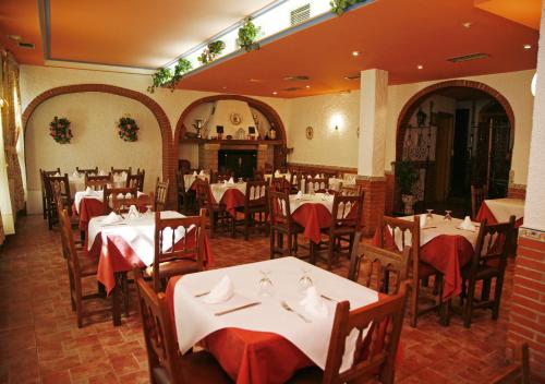 a restaurant with white tables and chairs with red napkins at Hostal Cuatro Esquinas in Ejea de los Caballeros