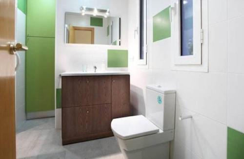 La salle de bains est pourvue de toilettes, d'un lavabo et d'un miroir. dans l'établissement Actual Home Gran Via, à Barcelone