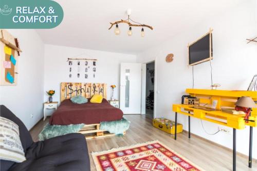 ein Schlafzimmer mit einem Bett und einem gelben Schreibtisch in der Unterkunft The Artist's Corner Brasov in Braşov