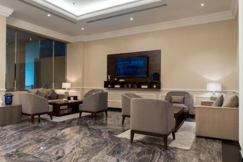 a lobby with a waiting room with chairs and a tv at فخامة الضيافة - Dyafa Luxury in Al Khobar