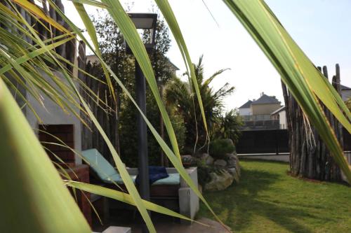 a view of a garden with a chair and plants at La Villa Thelma 5 étoiles, piscine, sauna et jacuzzi in Granville