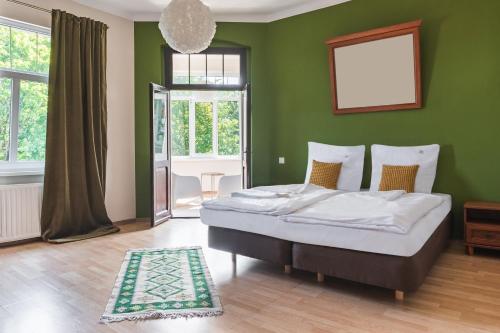 een slaapkamer met een bed met een groene muur bij Perła Świeradowa in Świeradów-Zdrój