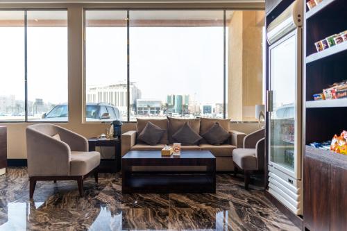 a lobby with a couch and chairs and windows at فخامة الضيافة - Dyafa Luxury in Al Khobar