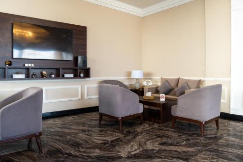 a living room with a couch and a table and chairs at Luxury Hospitality Serviced Apartments in Al Khobar