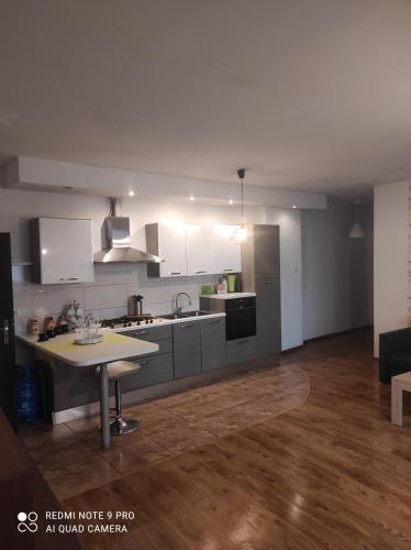 a kitchen with white cabinets and a table in a room at Apartamenty centrum in Wałbrzych