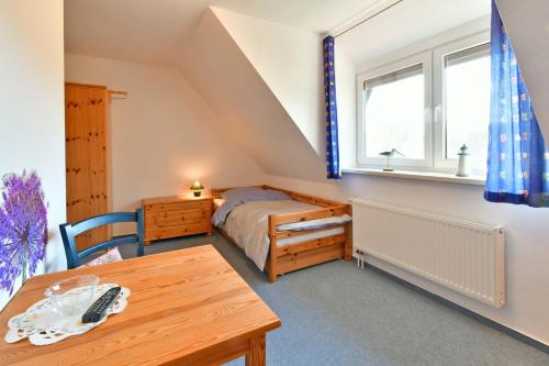 a small bedroom with a bed and a table at Lee in Zingst
