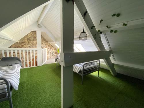 Habitación en el ático con alfombra verde y escalera en Sunset Bricqueville sur mer, en Bricqueville-sur-Mer
