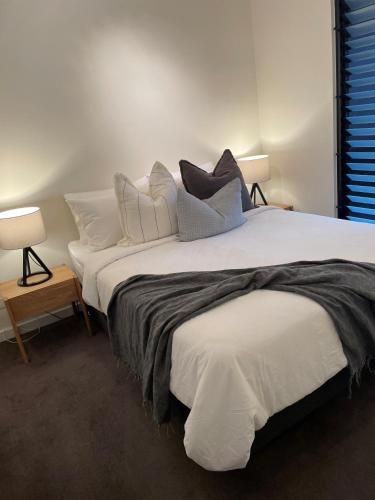 a bedroom with a large white bed with pillows at Heart of St Kilda in Melbourne