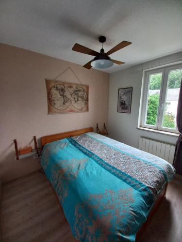 a bedroom with a bed with a ceiling fan at Le secret de la Glycine in Lillebonne