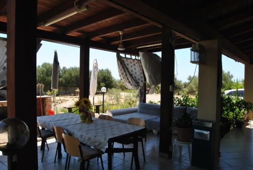 eine Terrasse mit einem Sofa, einem Tisch und Stühlen in der Unterkunft Villa Maria in Maracalagonis
