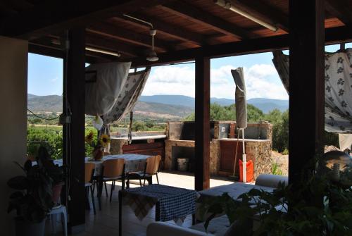 a patio with a table and chairs and mountains in the background at Villa Maria in Maracalagonis