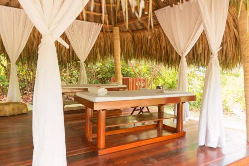 uma mesa no meio de uma sala com cortinas em Ecohabs Tequendama Playa Cañaveral Parque Tayrona em El Zaino