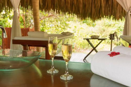 two glasses of champagne sitting on a table in a room at Ecohabs Tequendama - Parque Tayrona in El Zaino