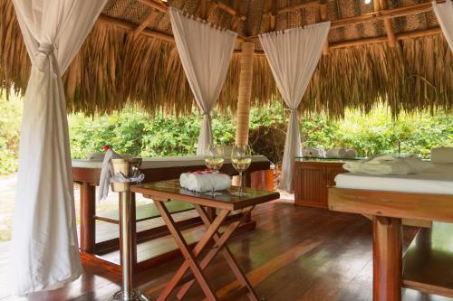 a room with two beds and a table with wine glasses at Ecohabs Tequendama - Parque Tayrona in El Zaino