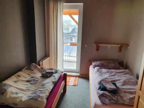 deux lits dans une chambre avec une fenêtre dans l'établissement Apartment mit Balkon, à Dresde