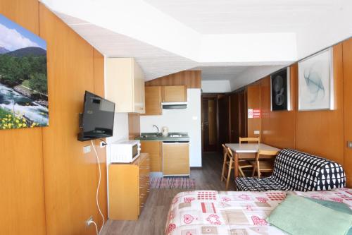 una camera con letto e una cucina con televisore di Marilleva 1400 Appartamenti Montana a Marilleva