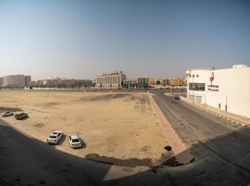 an empty parking lot with two cars parked in it at Luxury Hospitality Serviced Apartments in Al Khobar