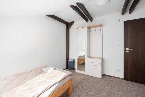 a bedroom with a bed and a closet and a mirror at Pokoje Wimbledon in Liberec