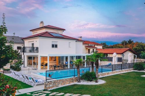 a large white house with a swimming pool at Cool Šilo Appartement Resort in Šilo
