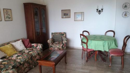 a living room with a couch and a table and chairs at BIBAHOME in Cogoleto