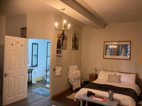 a bedroom with a bed and a table and a chandelier at 7 Dagnaud De la Tude our family farmhouse style home with en-suite in Montboyer