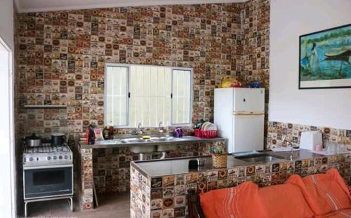 uma cozinha com um fogão e um frigorífico em Pousada da Sú em Bertioga
