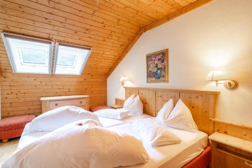 una camera con 2 letti con cuscini bianchi di Gasthof-Appartements Sportalm a Bad Kleinkirchheim