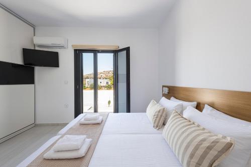 a bedroom with a large white bed with white pillows at Villa Veta with Private Swimming Pool in Angairiá