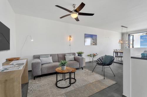 a living room with a couch and a ceiling fan at Grand Windsock Bonaire in Kralendijk