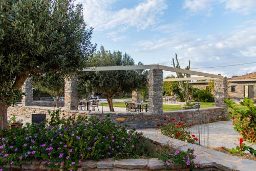 a pavilion with flowers in a garden at Holiday Rooms in Otzias