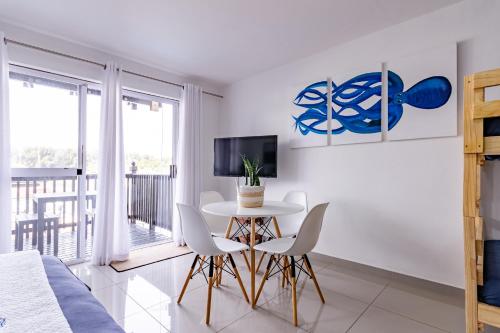a bedroom with a table and chairs and a tv at Mzingazi Waterfront Accommodation, On The Bay Waterfront Villa's in Richards Bay