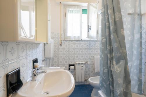 uma casa de banho com um lavatório e um WC em [VIA CRISPI] Grande e comodo in zona tranquilla. em Pietra Ligure