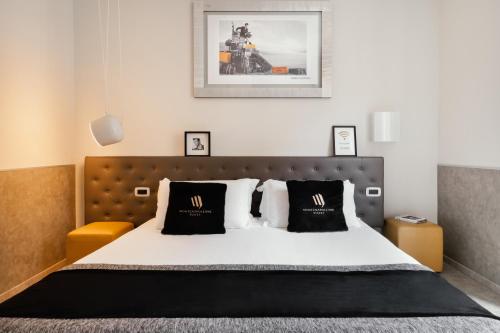 een slaapkamer met een bed met zwart-witte kussens bij Montenapoleone Suites in Milaan