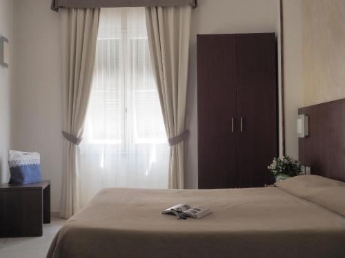 a bedroom with a bed and a large window at Hotel Margherita in Monterosso al Mare