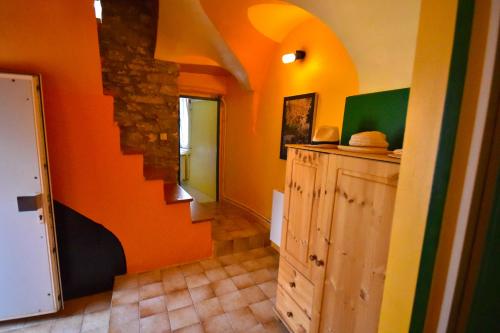 un pasillo con una pared de color naranja y una escalera en Roman Tower, en Cipressa